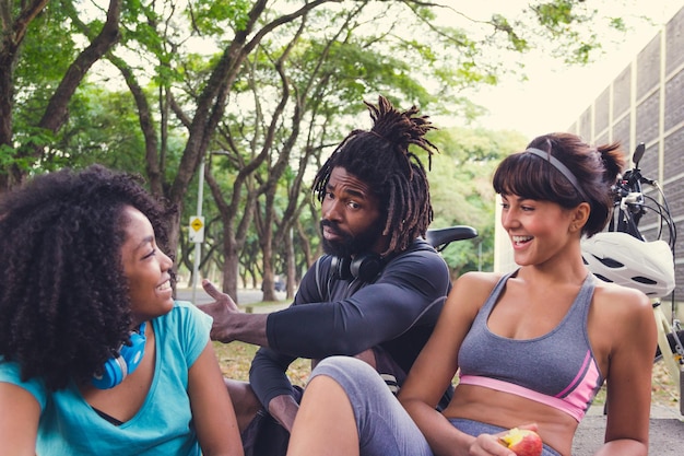 friends talking while relaxing against trees 1048944 23979518